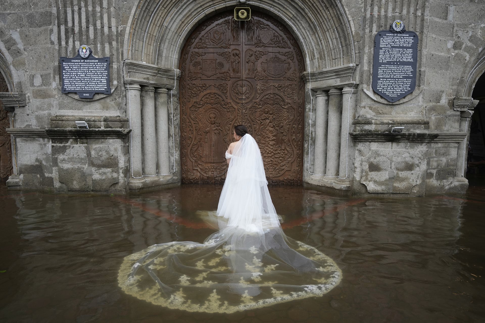 Bride Jamaica Aguilar prepares to enter the flooded Barasoain Church in Malolos, Bulacan province, Philippines for her wedding. The Barasoain Church, a national landmark, is situated in a region where nearly 75% of the population is exposed to flooding hazards.